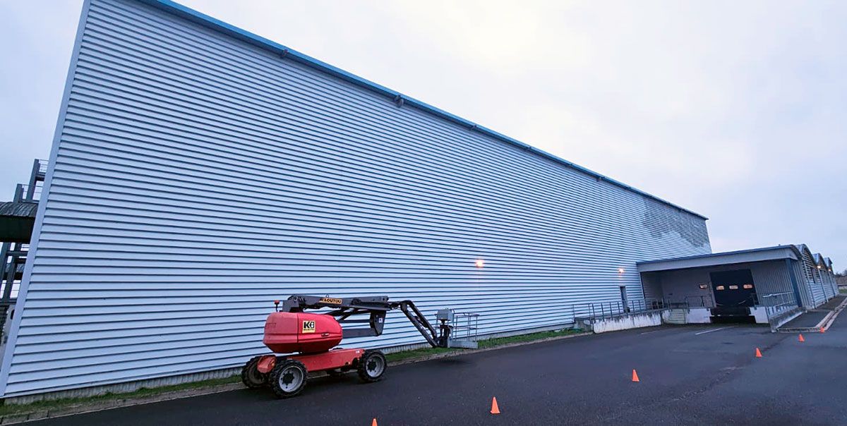 Chantier en cours de nettoyage de façade industrielle